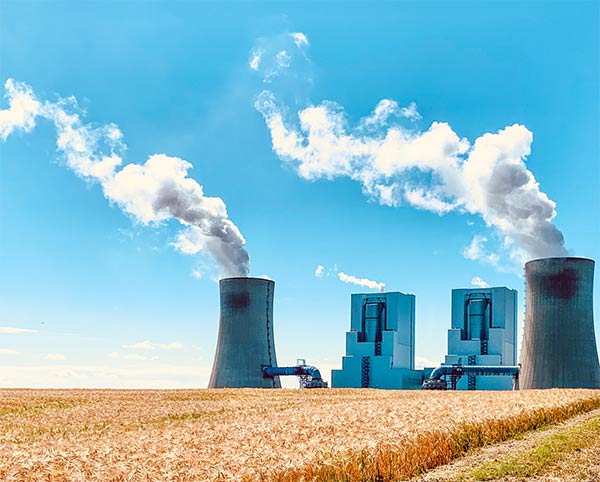 Pšeničné pole s jadrovou elektrárňou v pozadí